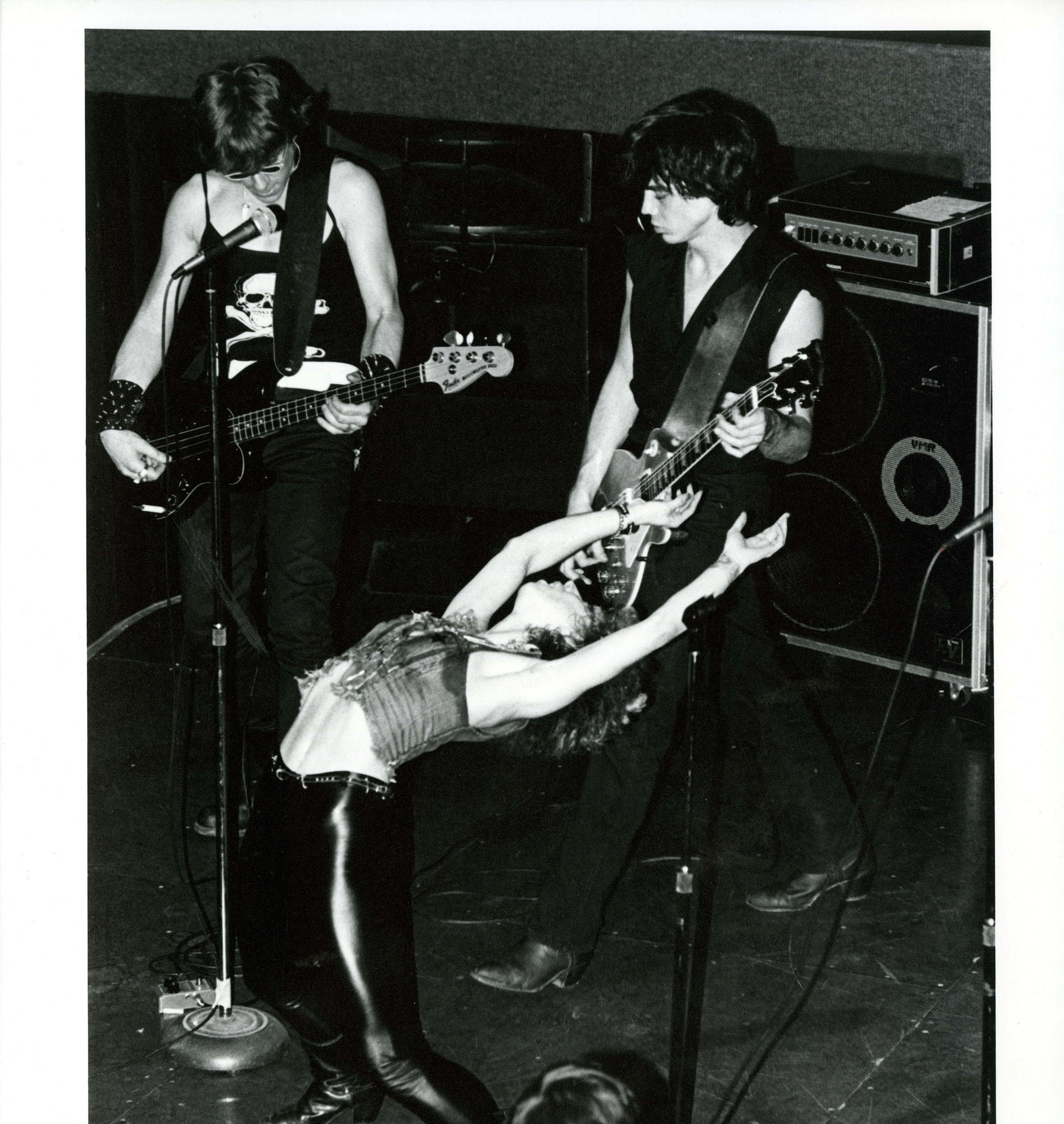 woman in leather pants bending backward while performing with a band